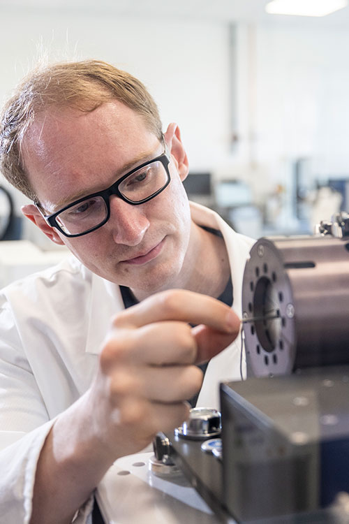 Mann mit Brille macht einen Radialkrafttest im Prüflabor